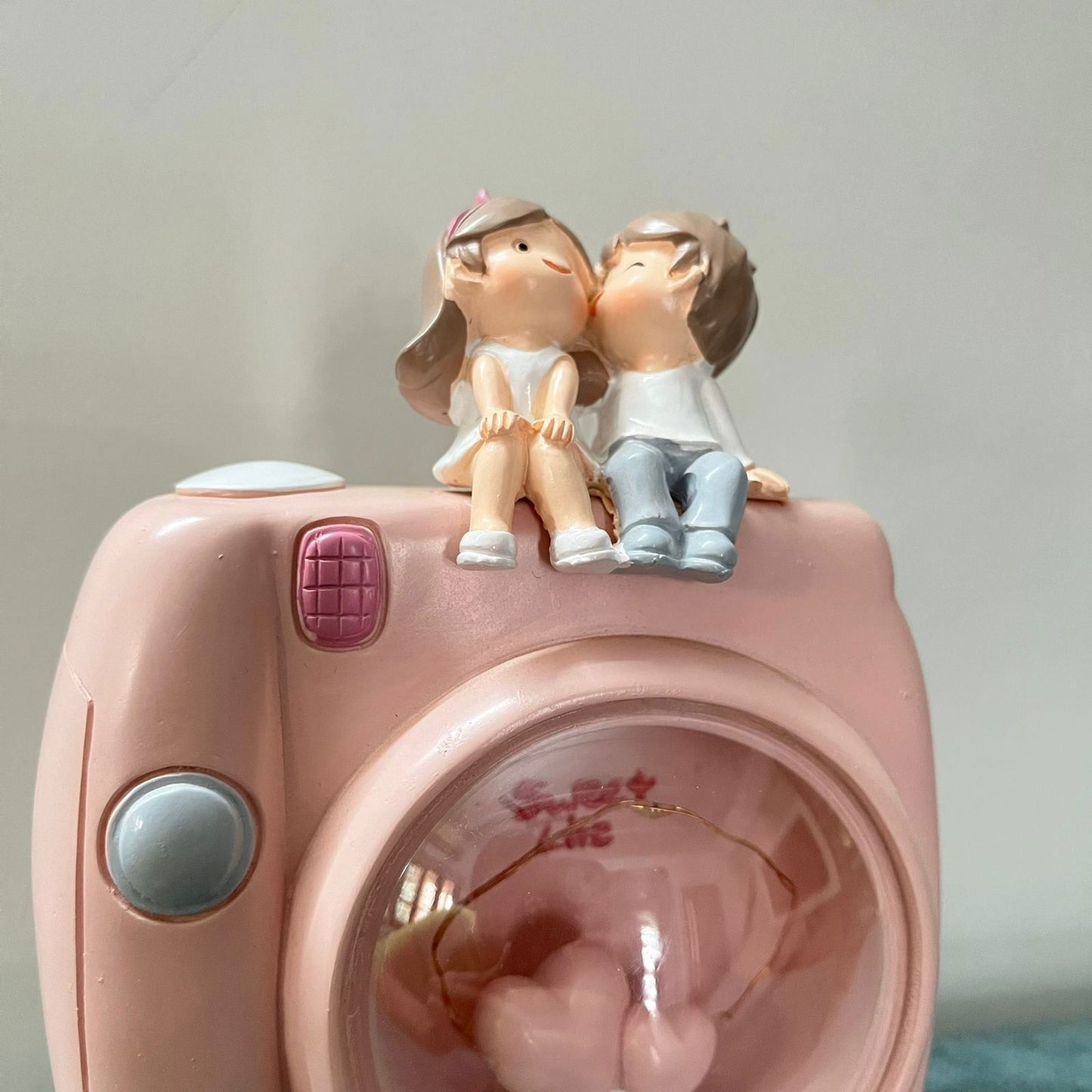 Couple Sitting On Camera Lamp -