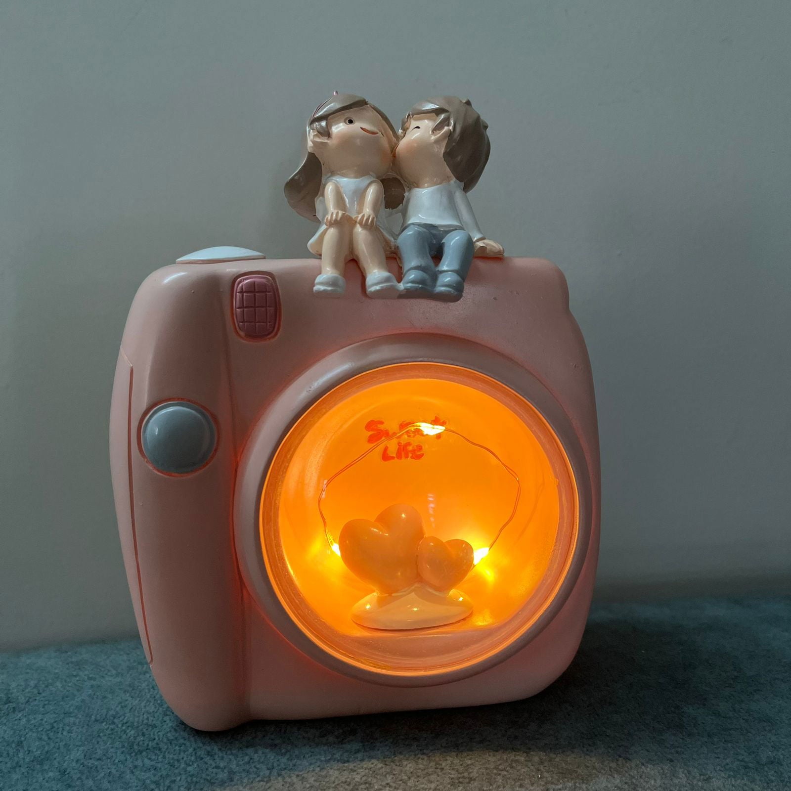 Couple Sitting On Camera Lamp - 